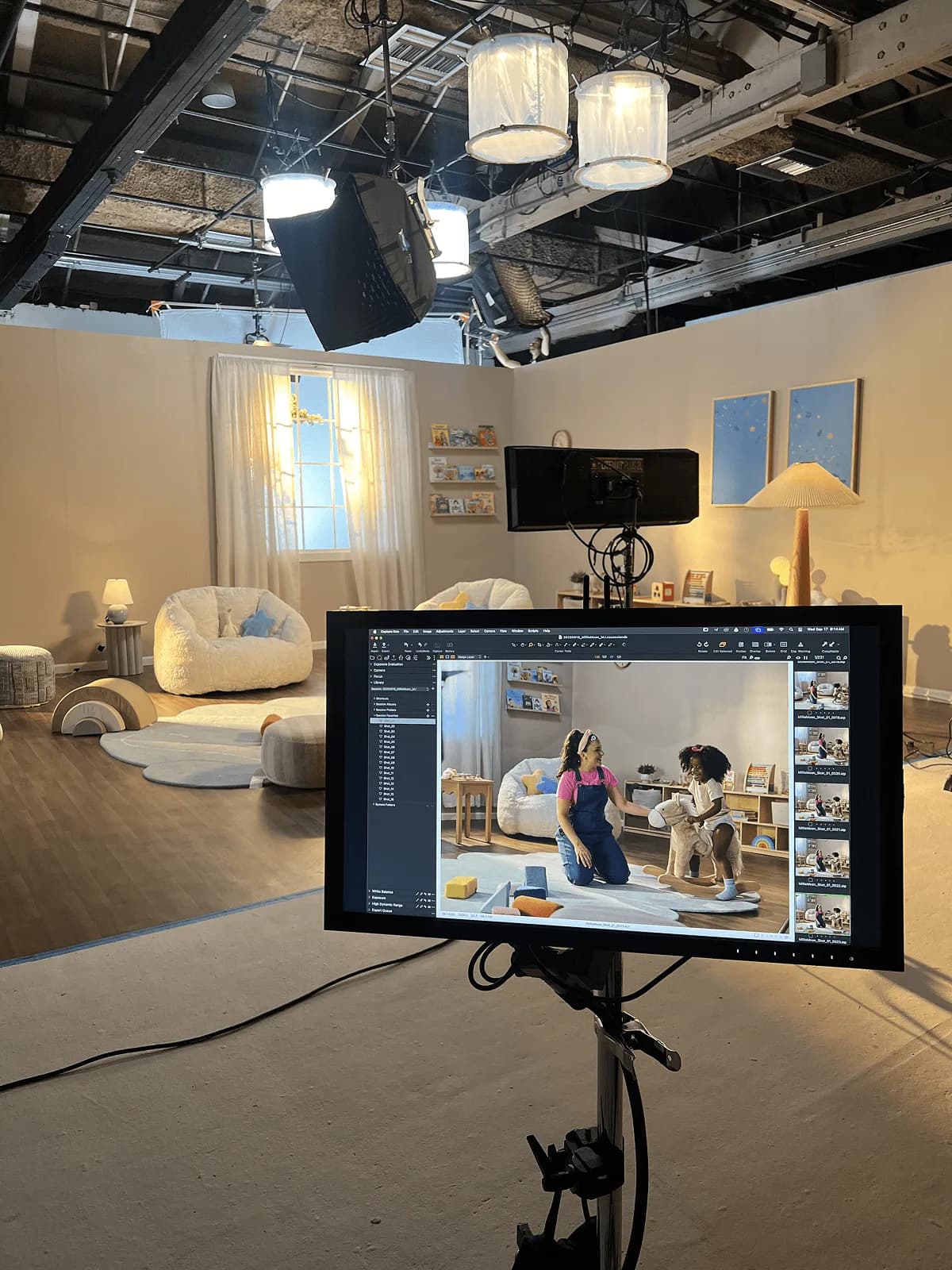 Photography studio set built as a playroom, where Ms. Rachel plays with a toddler on a rug