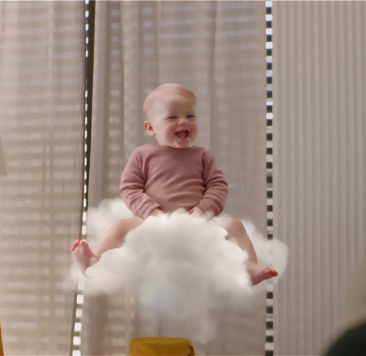 Smiling baby sitting on a soft white cloud, illustrating Millie Moon Cloud Touch softness