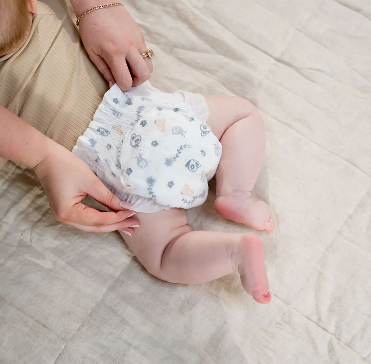 Parent stretching the waistband of a Millie Moon diaper on a baby to show its strength
