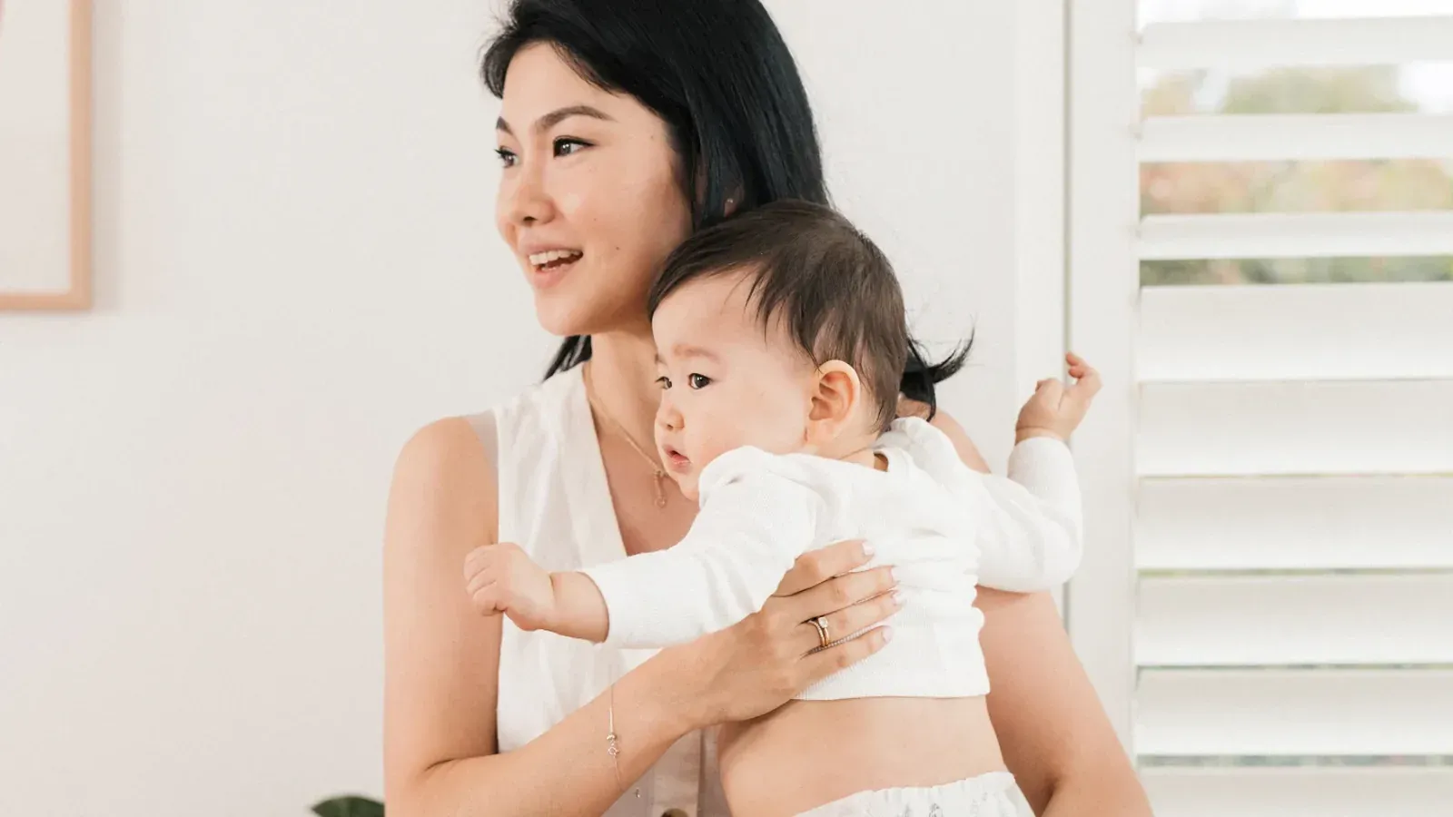 A parent holding a baby in a diaper against one hip